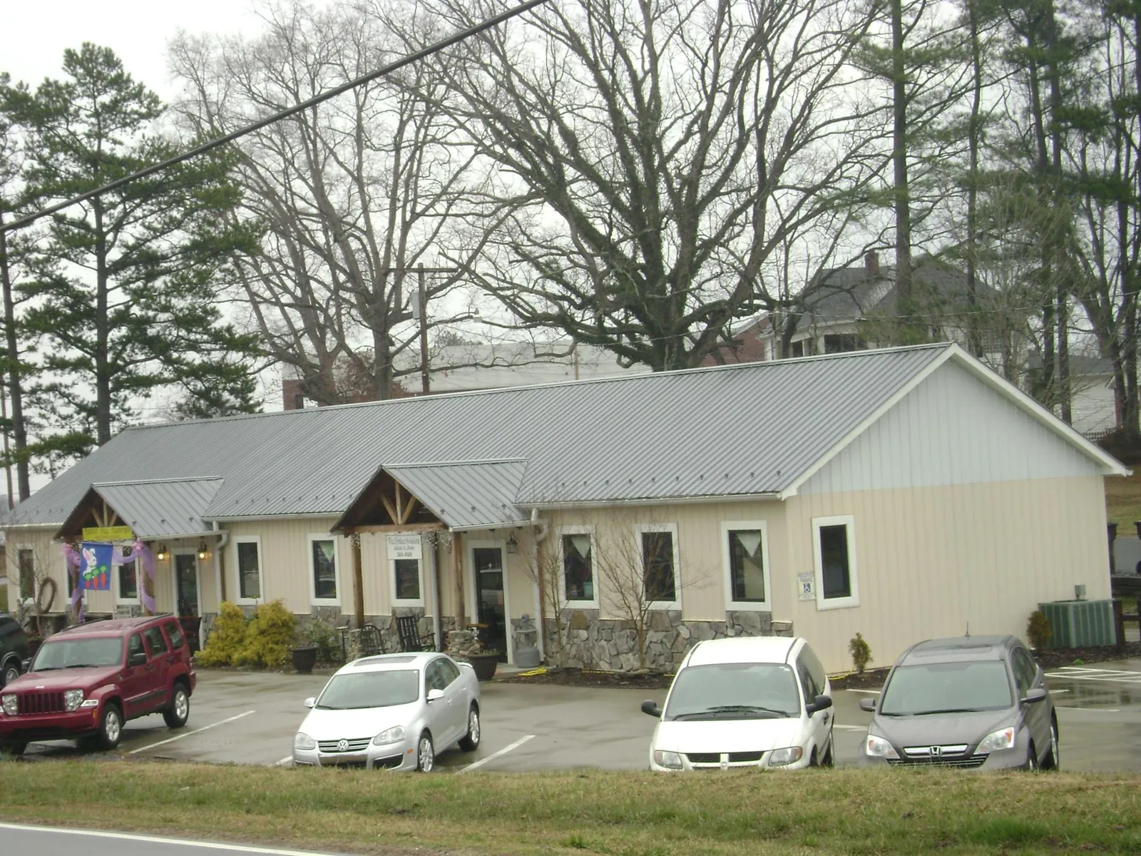 Gray metal roof with timber entry brackets on a small commercial building in Lincoln
