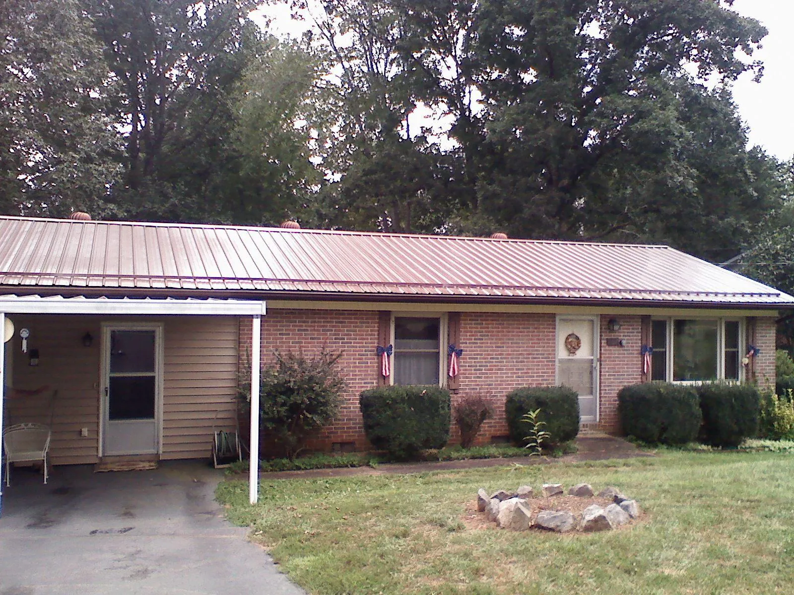 Bronze metal roof and carport on a brick ranch home — Roof Repair work by our crew in Lincoln